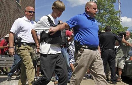 Shooting suspect Dylann Storm Roof, second from left, is escorted from the Shelby, N.C.  police department Thursday. 
